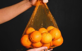 a-fresh-orange-inside-of-a-fruit-net-3683206